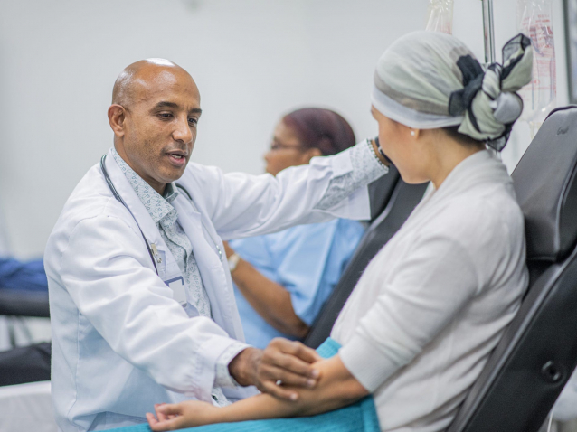 Doctor giving IV drip treatment to cancer patient